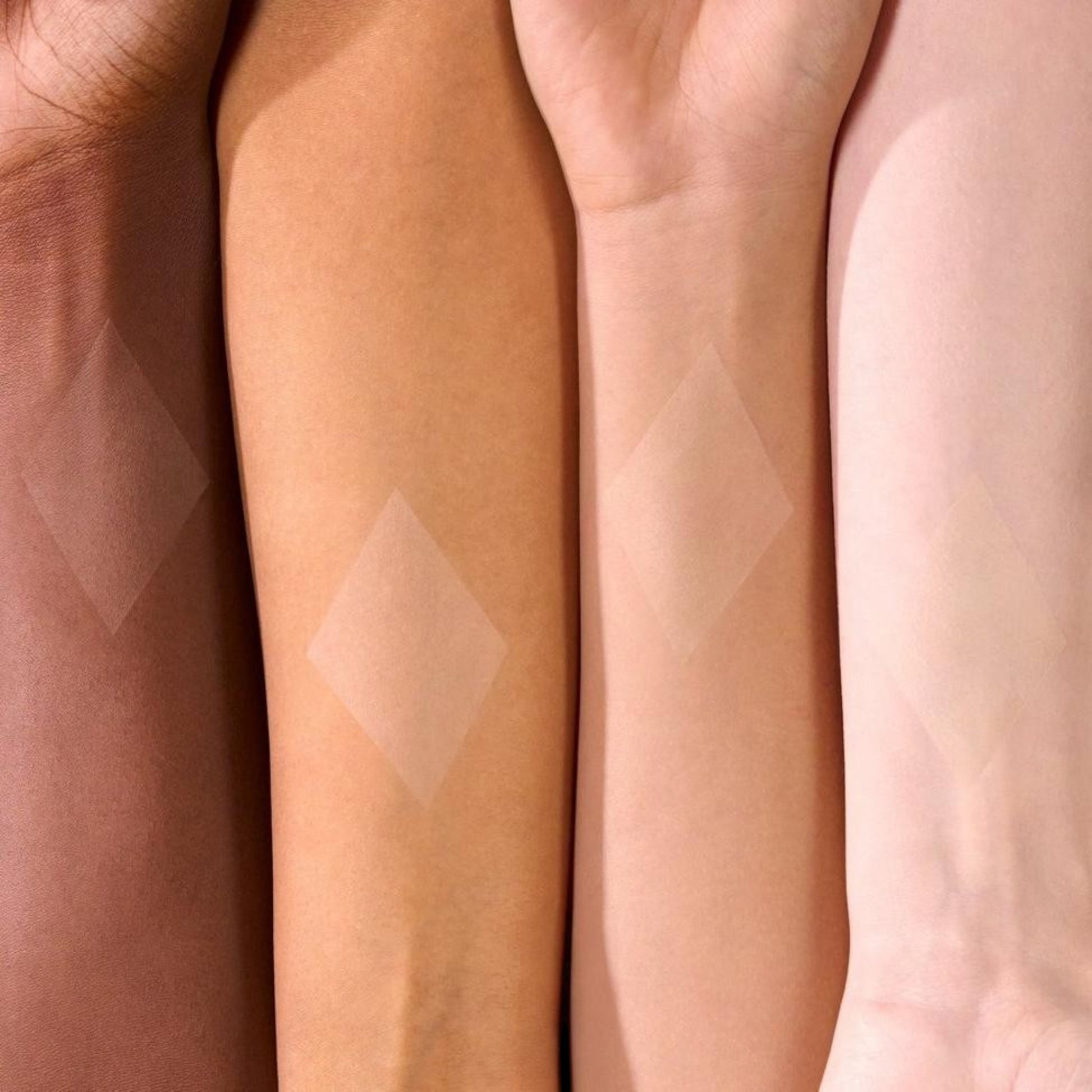 Banana loose powder swatched on four different skin tones to show its translucent yellow matte finish.