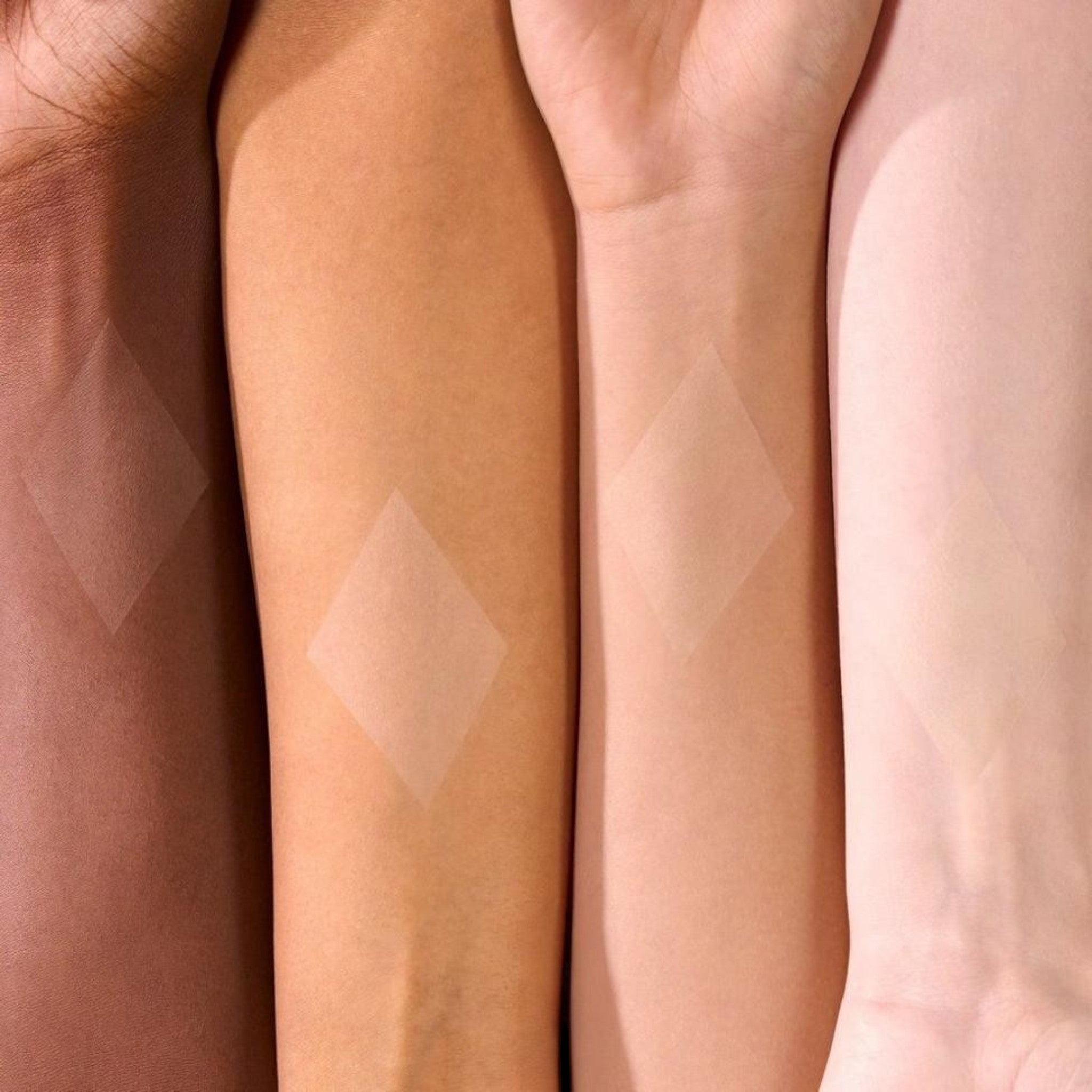 Banana loose powder swatched on four different skin tones to show its translucent yellow matte finish.